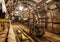 Interior of underground mine passage with rails, light and carriage