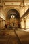 An interior view of an abandoned Hebrew Jewish synagogue bathed in rays of light.