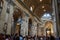 Interior view of the Basilica of Saint Peter in the Vatican with sculptures, roof and crowd of people visiting the main altar