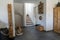 Interior view of an elegant hallway and stairs with black tile floor and white plaster walls and wooden furniture and decorative