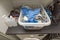 Interior view of laundry cabinet.  Basket with clean clothes and iron over washing machine