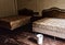 Interior view of a room with a couple of beds in an abandoned building