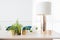 Interior view of small gold picture frame, lamp and a small plant pots on wooden table