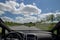 Interior view of sports car dashboard and panoramic windscreen of autonomous car. Driving on empty city street with no traffic.