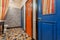 Interior of vintage style toilet room with old wooden doors to bathroom. Blue and red doors over colorful floor tiles