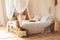 Interior white bedroom in boho  style with coffe table,straw lamp and comfortable bed with pillows, copy space. bed with flowing w