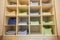 Interior of white plastic cabinet or clothing open wardrobe with stacked piles of clean colorful linen on shelves. Furniture