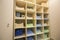 Interior of white plastic cabinet or clothing open wardrobe with stacked piles of clean colorful linen on shelves. Furniture