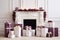 The interior of a white room with a fireplace and burgundy Christmas gifts