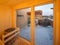 Interior of wooden finnish sauna with glass door. Private house.