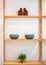 Interior wooden stand with shelves, plants, bowls and decorative elements.