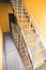 Internal metal fire escapes of a modern building, modern metal ladder. Fire escape in a modern house with yellow walls
