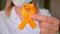 International Childhood Cancer Day. Female doctor in white coat holds yellow ribbon. Sarcoma Awareness, bladder cancer