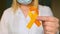 International Childhood Cancer Day. Female doctor in white coat holds yellow ribbon. Sarcoma Awareness, bladder cancer. Leukemia c