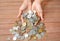 International coins full female hand on wood plank background