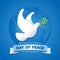International day of peace banner with white dove with leaf on blue circle wolrd background vector design