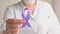 International Epilepsy Day. Doctor in coat holds Purple ribbon. Alzheimer's disease, Pancreatic cancer, Hodgkin