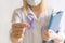 International Epilepsy Day. Doctor in coat holds purple ribbon on white background. Alzheimer`s disease, Pancreatic cancer,