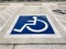 International handicapped wheelchair or Disabled parking symbol painted in bright blue on parking space