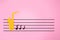 International Jazz Day. Silhouette of a saxophone cutted out of felt with notes, on a pink background in the form of a