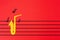 International Jazz Day. Silhouette of a saxophone cutted out of felt, from which notes fly out, on a red background in