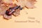 International Music Day background with miniature violin and autumn leaves.