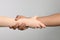 International relationships. People holding hands on light grey background, closeup