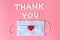 International`s nurses week concept, Text Thank you by tablets and red heart on pink background.
