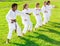 International team of tweens exercising taekwondo techniques on green lawn