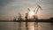 international trade, industrial river port with cranes for loading and unloading cargo ship backdrop of sunset sky