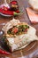 International vegetarian  shawarma sandwich roll with chili and spices. served at wooden table. arabian and caucaisian cuisine.