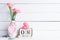 International Womens day concept. Pink carnation flower in vase and red heart with March 8 text on wooden block calendar on white
