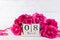 International Womens day concept. Pink roses with March 8 text on wooden block calendar on white wooden background