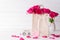 International Womens day concept. Pink roses in paper bag with March 8 text on wooden block calendar on white wooden background