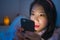 Internet addict Asian girl mesmerized with hand phone , young beautiful Chinese woman in pajamas enjoying with mobile phone in bed