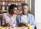 Internet addiction. Millennial black guy and girl looking at mobile phones on dull date at cafe