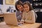 The internet is a great learning tool. a young girl studying with her mother nearby to help.