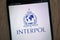 Interpol International Criminal Police Organization logo displayed on a modern smartphone