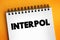 Interpol - international organization that facilitates worldwide police cooperation and crime control, text concept on notepad