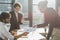 Interracial businessmen holding document near laptop