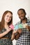 Interracial charming couple wearing casual clothes holding up large puzzle pieces and interacting happily, white studio