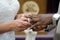 Interracial couple exchanging wedding rings and vows at marriage ceremony