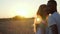 Interracial couple kissing at sunset.
