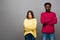 Interracial couple in knitted sweaters on grey background