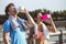 Interracial couple, Latina and Caucasian drink from a bottle of water with a towel around their neck after outdoor sports