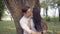 Interracial couple share tender kiss under a tree in Benchakitti park in Bangkok