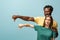 Interracial couple showing thumbs down isolated on blue background