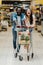 Interracial couple smiling while running while shopping cart in supermarket