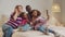 Interracial family with girls taking selfie on bed