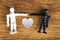 Interracial love concept with wooden figurines on wood background